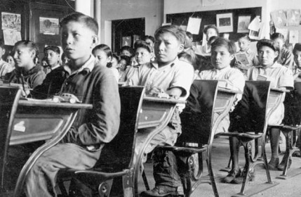 Archival photograph of Indigenous students inside a Residential School classroom