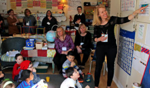 A teacher leading the Daily Calendar lesson with her students and other educators