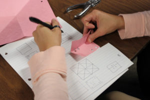 A Donald Young teacher demonstrates use of visualization during the Paper Folding/Hole Punch activity