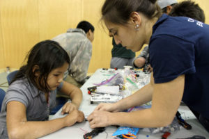 U of T Engineering Outreach student helps a girl with her circuit